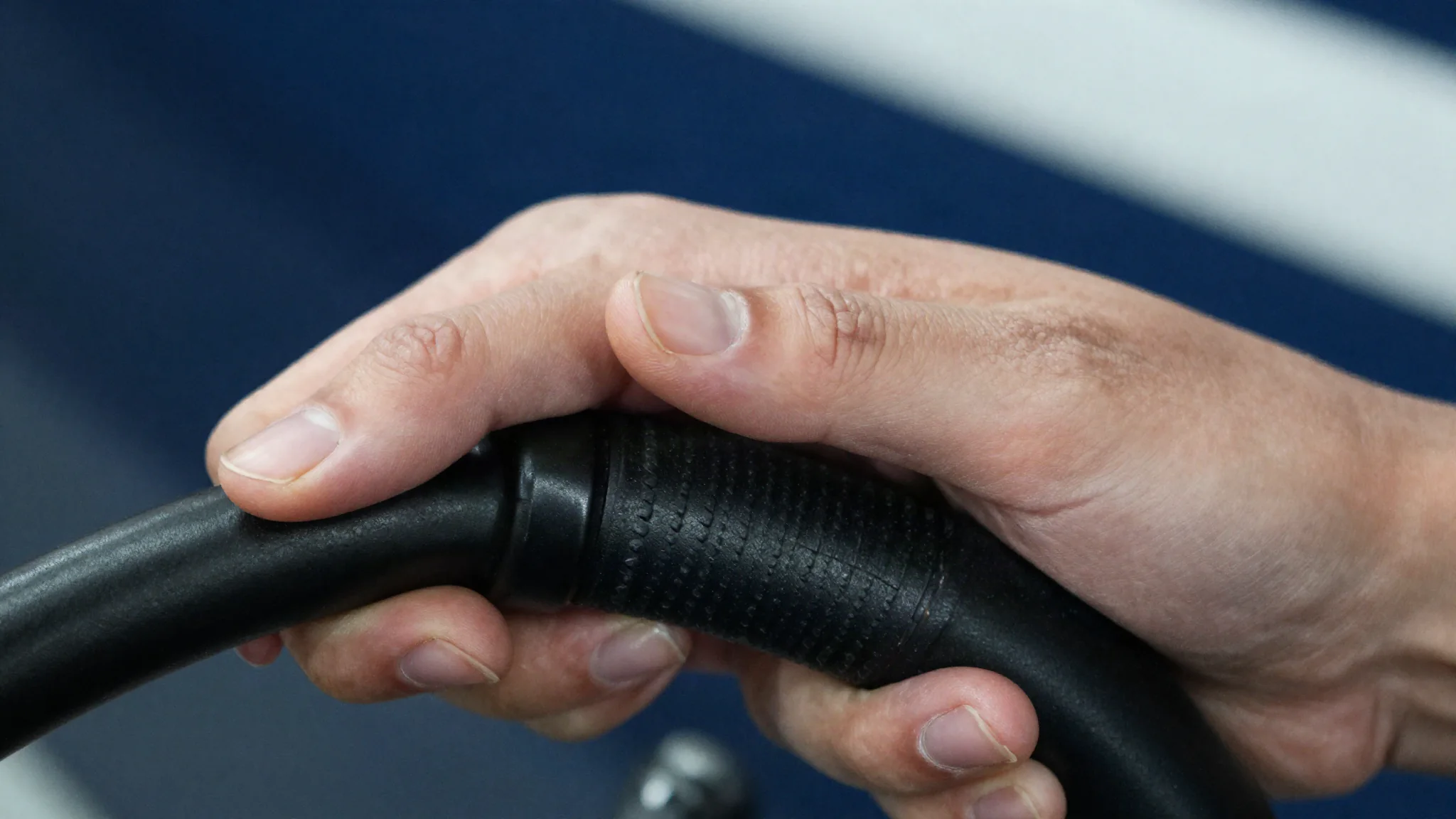 Close detail of hands establishing a deliberate grip on a resistance handle.